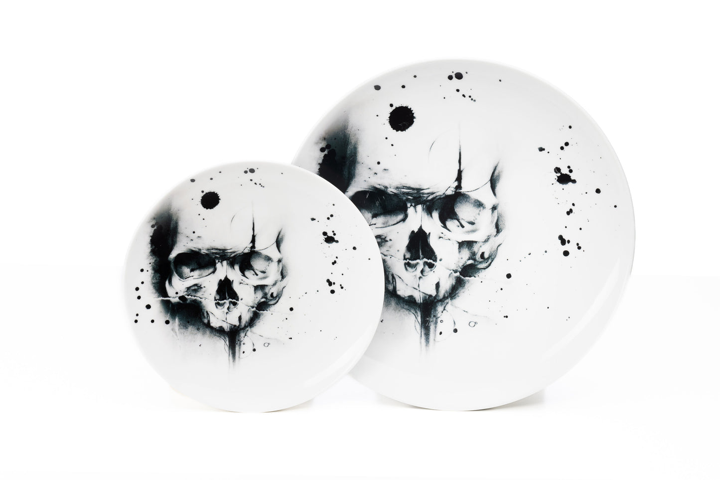 Dinnerware set of 4, 6, 8 containing one white porcelain dinner plate, and one salad plate each with cool skull illustration and black ink splatter dishwasher and microwave safe product photo on white background