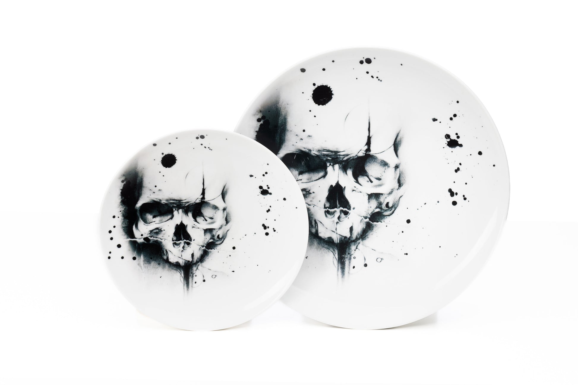 Dinnerware set of 4, 6, 8 containing one white porcelain dinner plate, and one salad plate each with cool skull illustration and black ink splatter dishwasher and microwave safe product photo on white background