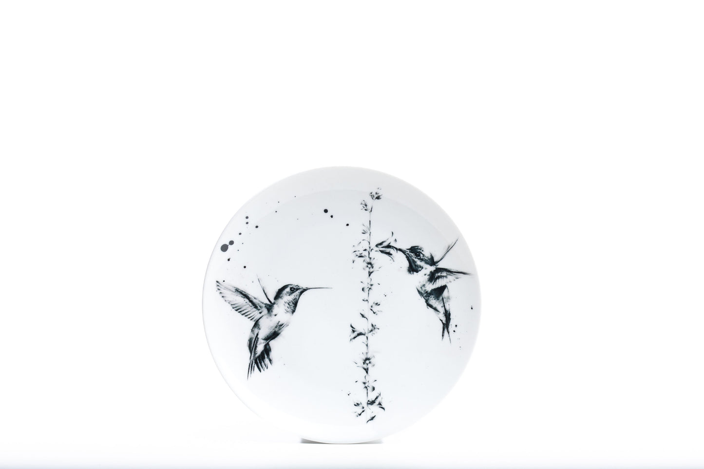 8" White coupe porcelain salad plate with two hummingbirds and a flower illustration and black ink splatter product photo on white background