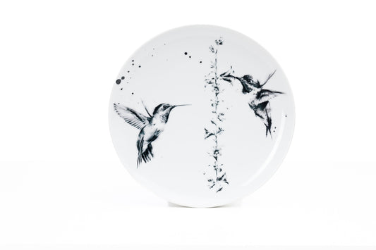11" White porcelain dinner plate, printed with two beautiful hummingbirds and a flower with some ink splatter, on a white background
