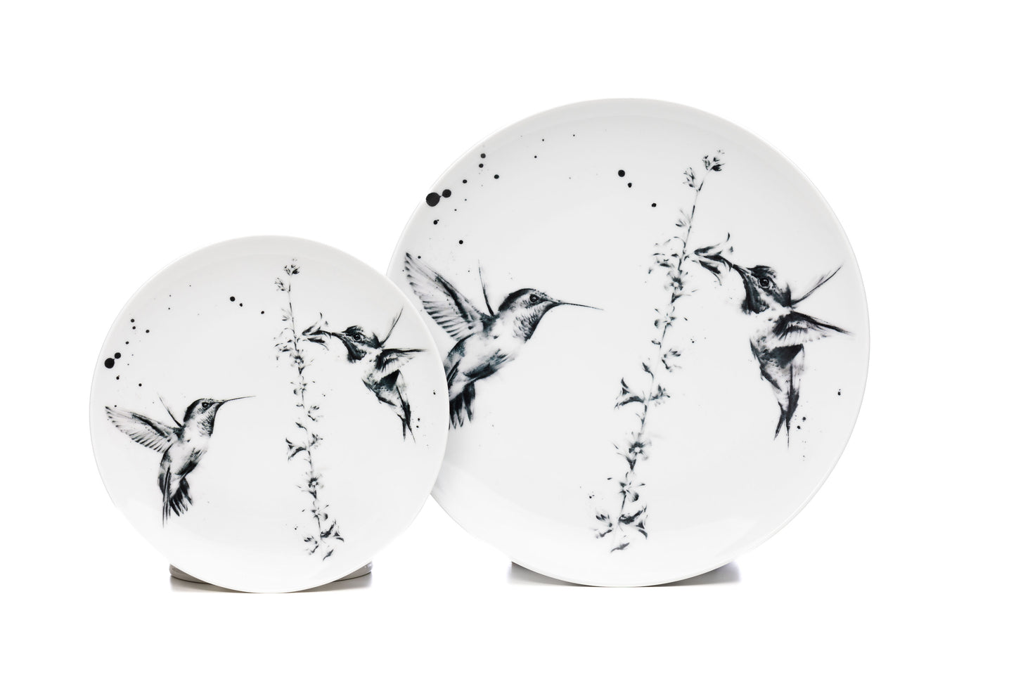 Dinnerware set of 4, 6, 8 containing one white porcelain dinner plate, and one salad plate each with 2 hummingbirds around a flower illustration and black ink splatter dishwasher safe product photo on white background